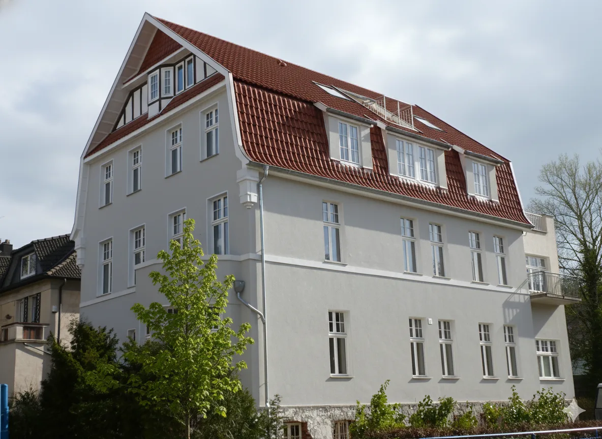Dachsanierung im Vorher-Nachher-Vergleich, links altes verwittertes Dach, rechts neu eingedeckt und gedämmt